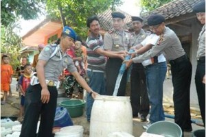 Jajaran Polres Kuningan saat membantu mengisikan air ke warga Cihanjaro